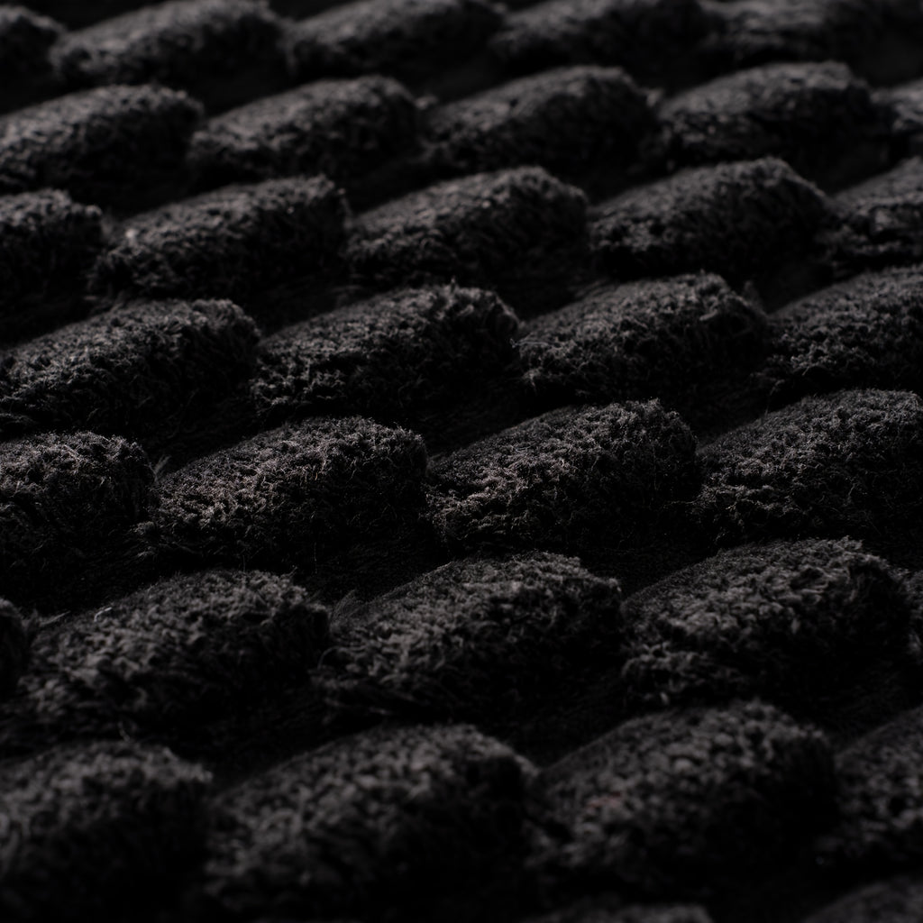 Tapis rond noir à bord festonné et relief floqué en bulles